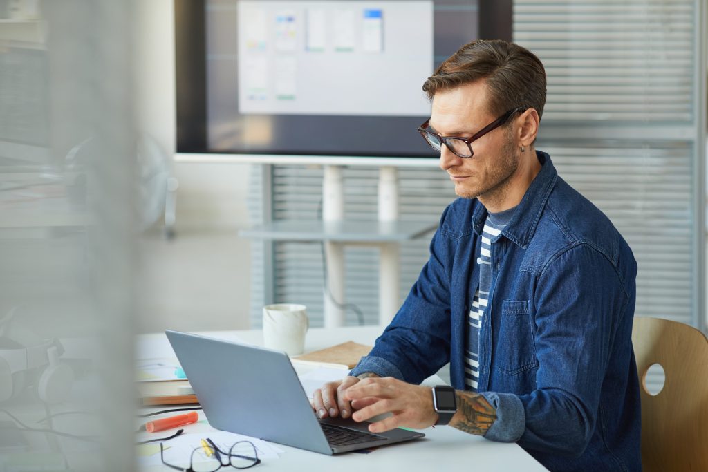 Man werkend achter laptop